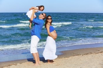 Family on the beach shore  pregnant mother