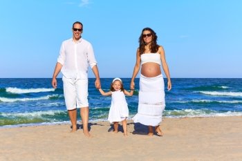 Happy family on the beach sand walking pregnant mother woman