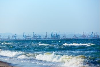 Valencia beach of El Saler with port cranes view in background at Spain