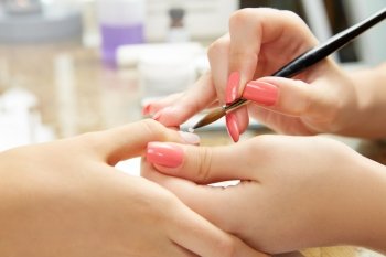 Nails painting with brush in Nail Salon woman hands