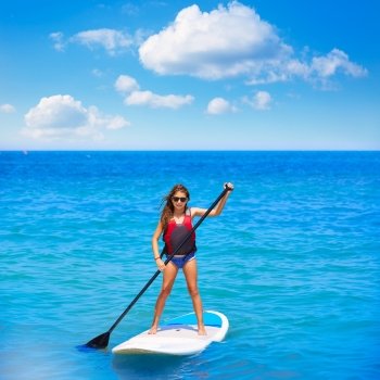 Kid paddle surf surfer girl with row in mediterranean beach