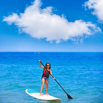 Kid paddle surf surfer girl with row in mediterranean beach