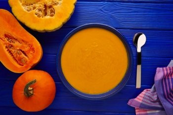 Pumpkin soup cream on a wooden table and ingredients