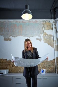 Architect woman working holding plan paper at office