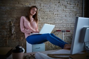 Businesswoman casual sitting at office working with laptop computer feet on table relaxed
