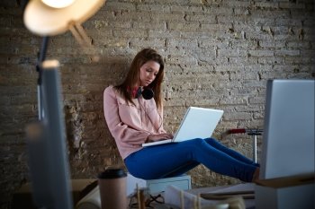 Businesswoman casual sitting at office working with laptop computer feet on table relaxed