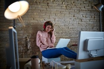 Woman hearing music headphones at office with laptop relaxed sitting