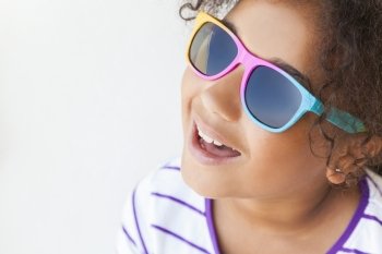 A beautiful and happy mixed race African American female girl child wearing sunglasses in bright sunshine on vacation shot with a white background
