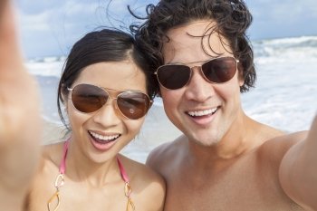 Man & woman Asian couple, boyfriend girlfriend in bikini, taking vacation selfie photograph at the beach