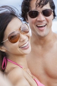 Man & woman Asian couple, boyfriend girlfriend in bikini, taking vacation selfie photograph at the beach