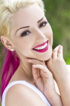 Outdoor portrait of a beautiful smiling woman or girl with brown eyes, perfect teeth, blond and magenta pink hair