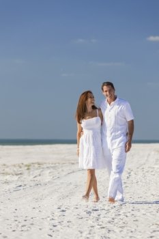 Romantic man and woman romantic couple in white clothes walking on a deserted tropical beach with bright clear blue sky