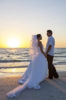 A married couple, bride and groom, together sunset sunrise on a beautiful tropical beach