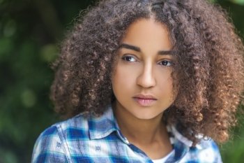 Outdoor portrait of beautiful happy mixed race African American girl teenager female child looking thoghtful or sad