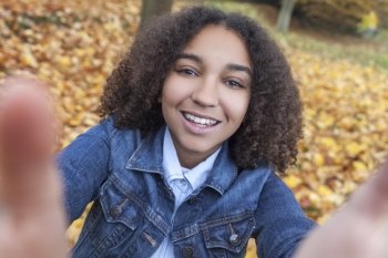 Beautiful happy mixed race African American girl teenager female child smiling with perfect teeth taking selfie photograph 