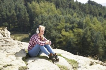 Teenage Girl Listening To Music In Countryside