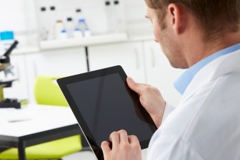 Scientist In Laboratory Using Digital Tablet