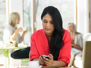 Woman Sending Text Message In Cafe