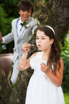 Page Boy And Bridesmaid Blowing Bubbles