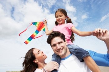 Father And Daughter Having Fun Flying Kite On Beach Holiday
