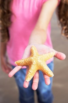 Close Up Of Girl Holding Starfish Found On Beach
