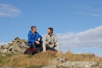 Two Men Stopping For Rest On Countryside Walk