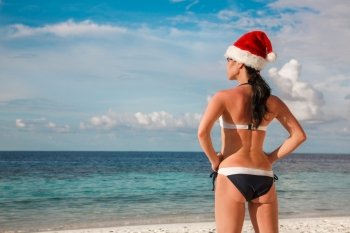 Christmas vacation - woman in santa hat on the beach