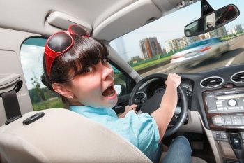 Woman in panic behind the wheel of the car. Driving lessons The woman behind the wheel..