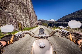 Biker rides a motorcycle on mountain serpentine. First-person view.