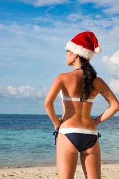 Christmas vacation - woman in santa hat on the beach