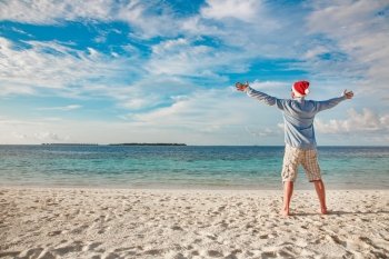 Christmas vacation - man in santa hat on the tropical beach