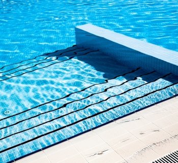 Stairs clear blue swimming pool background
