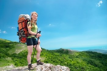 Happy young hiking woman with backpack on the mountain 