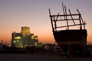 Dawn breaking behind the then still unfinished Museum of Islamic Art in Doha, Qatar, and a dhow in the now reslocated repair yard in September 2006
