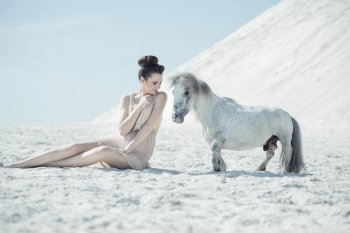 Charming woman playing with the pony