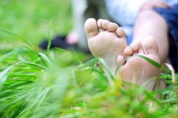 Little boy’s feet on fresh grass