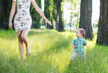 Beautiful mom playing in the park with her child
