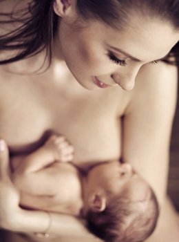 Young beautiful mom hugging her newborn toddler