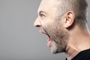 angry man screaming isolated on gray background with copyspace