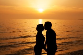 Couple kissing at sunset on the seashore

