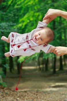 Baby in ukrainian folk dress vyshyvanka in father’s hands