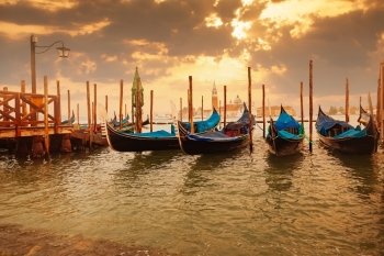 Gondolas at sunset pier near San Marco square in Venice, Italy
