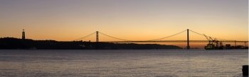 Sunset view of The 25 de Abril Bridge in Lisbon, Portugal, panorama
