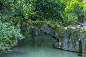 Stone bridge and pool in Quinta da Regaleira, Sintra, Portugal
