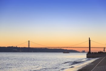 Sunset view of The 25 de Abril Bridge in Lisbon, Portugal, panorama
