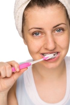 Teenage girl with braces brushing teeth on white background
