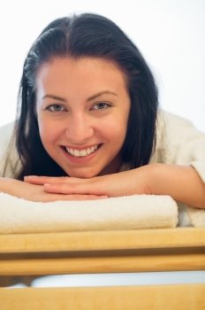 Closeup of smiling woman resting on bed at beauty spa