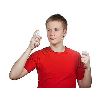 The boy, the teenager spraying fragrance perfume

