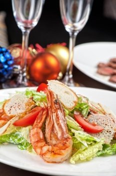 Tasty shrimp salad with vegetables on christmas table