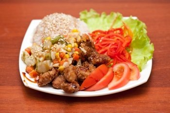 rice with roasted meat and vegetables. plate of chinese rice with roasted meat and vegetables